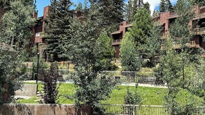 Un edifici d'edificis amb balcons, envoltat d'arbres i una zona verda.