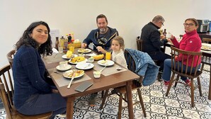 Uma mesa de jantar com pratos de comida, uma garrafa de suco e um smartphone.