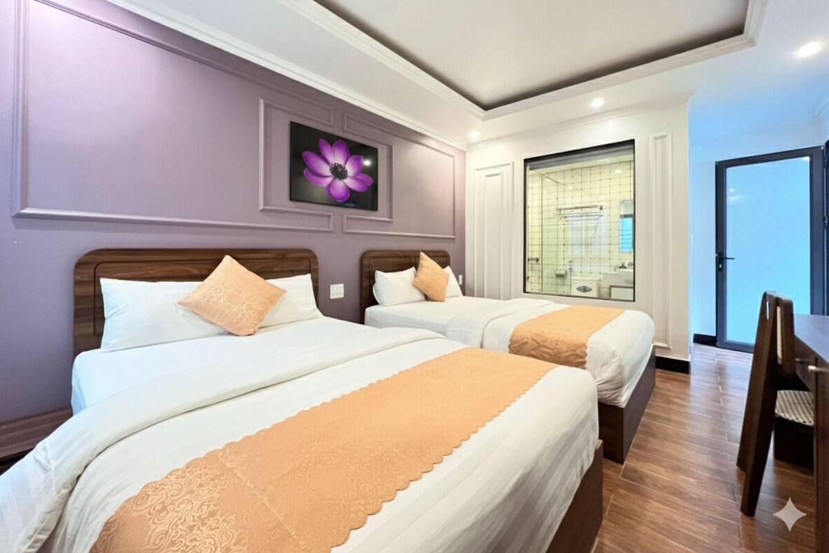 A hotel room with two beds, a dining table, and a large window.
