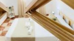 Une chambre d’hôtel moderne dotée d’un design architectural unique, avec une structure en bois aux lignes courbes et une table blanche placée au centre.