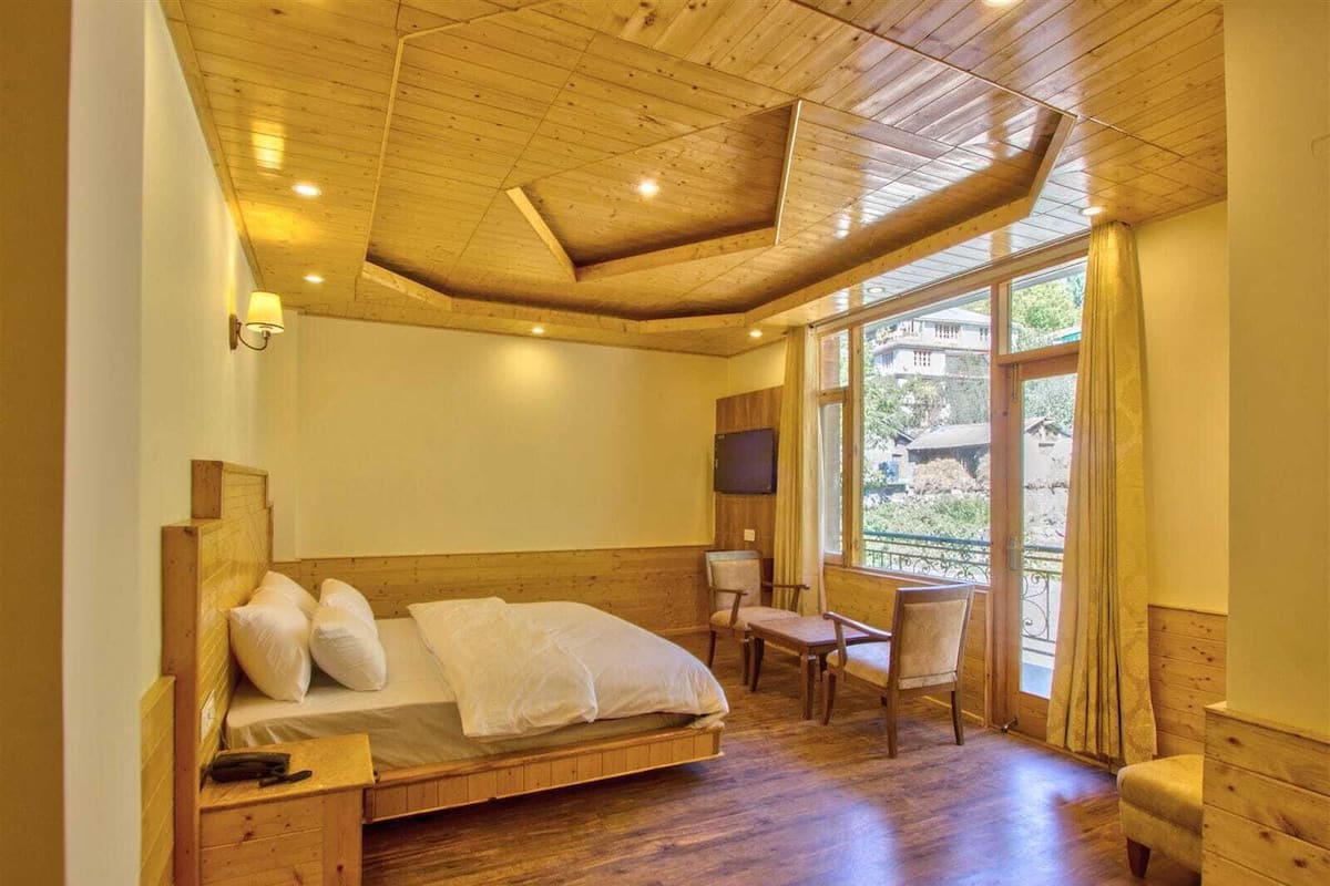 A wooden room with a bed, a desk, and a chair.