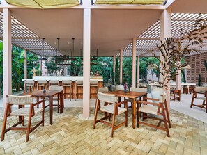 Enjoy a casual dining experience surrounded by lush greenery under a transparent roof.