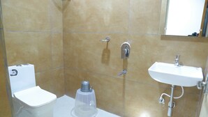 A bathroom with a toilet, bidet, and sink. - Anika Suites (Hyderabad)