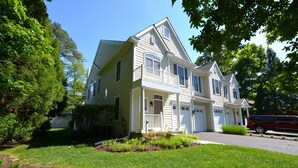 A two-story house with a front porch, garage, and a driveway. - BEAUTIFUL HOME IN THE HIGHLY SOUGHT AFTER CANAL CORKRAN (Rehoboth Beach)