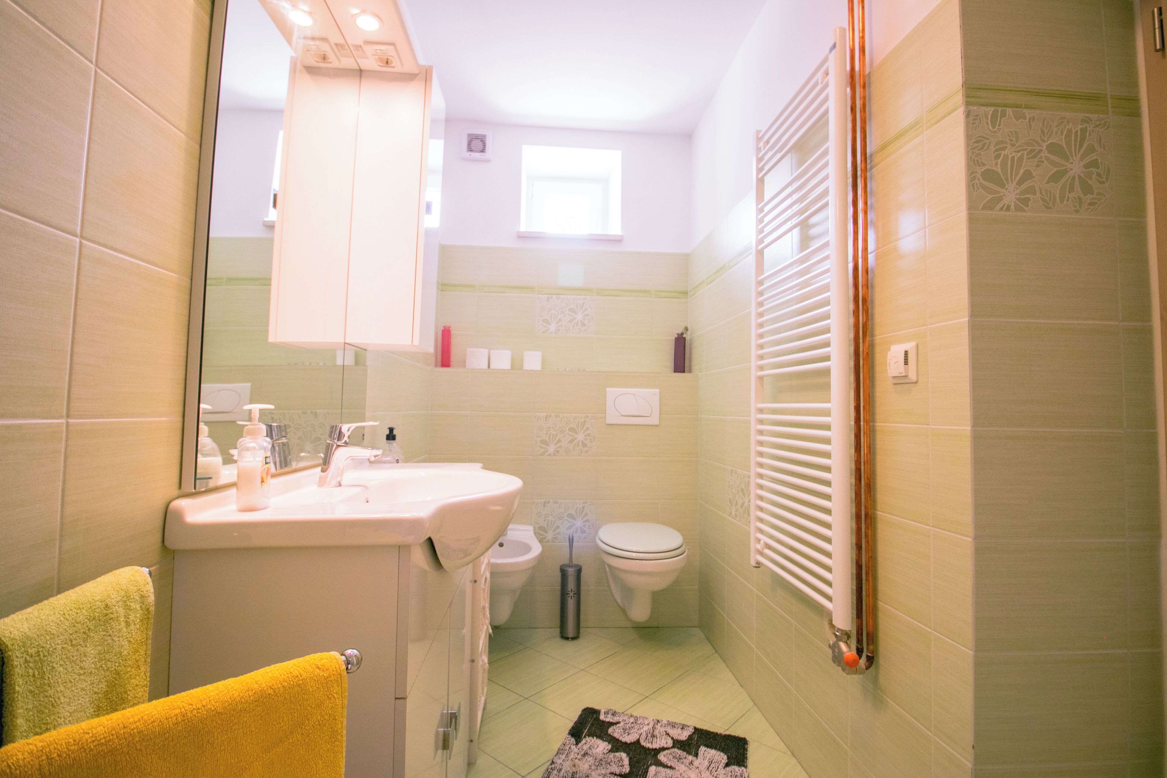 Ein kleines Badezimmer mit Waschbecken, Toilette und Handtuchhalter.