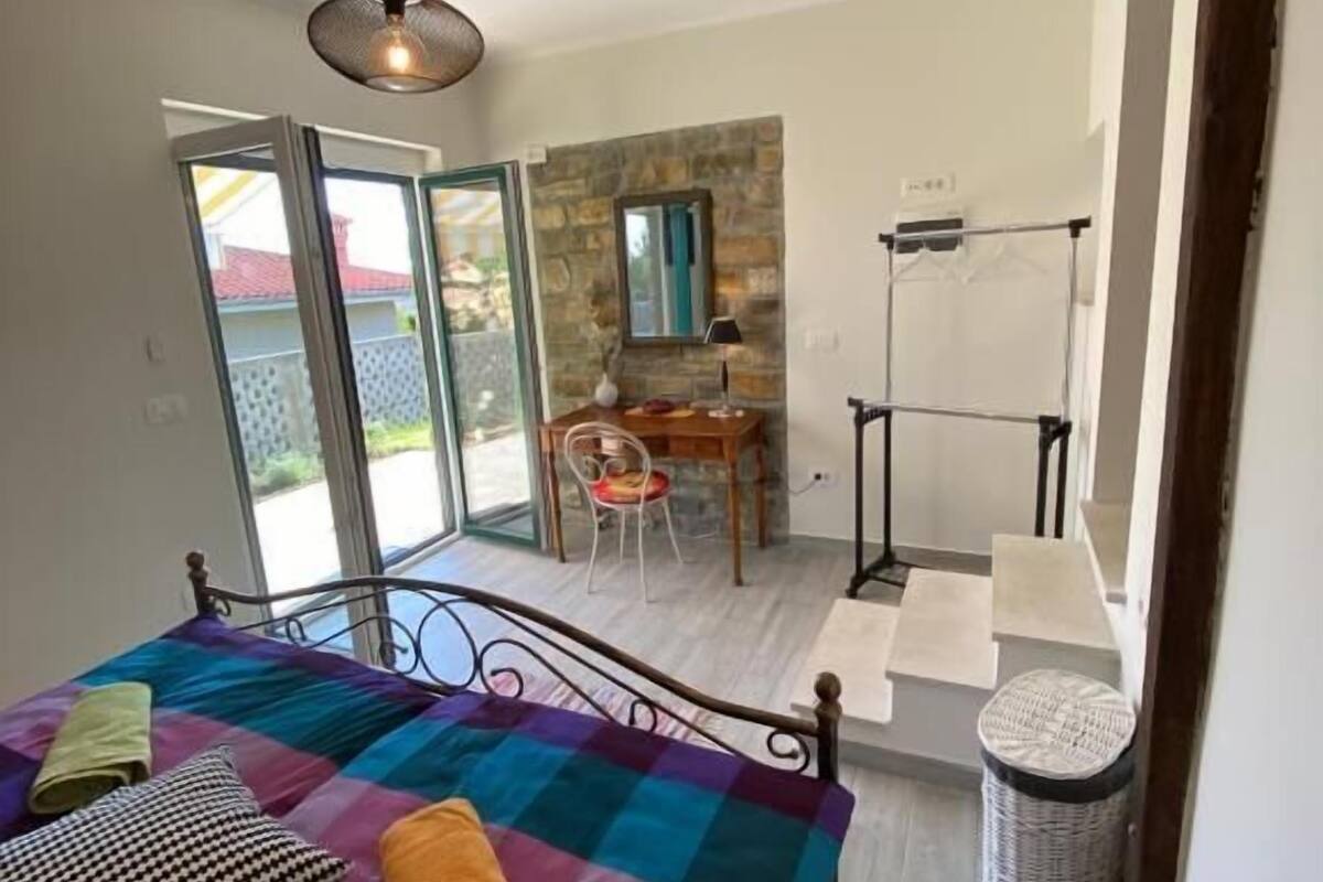 A bedroom with a bed, a desk, and a chair.