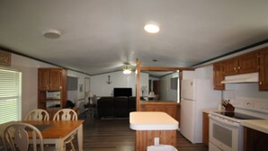 A compact kitchen with wooden cabinets, a countertop, and a stove. - 334 N Harbor - Perfect Place to getaway & relax! (Port Mansfield)