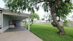 A covered patio area with a concrete walkway leading to a building. - 334 N Harbor - Perfect Place to getaway & relax! (Port Mansfield)