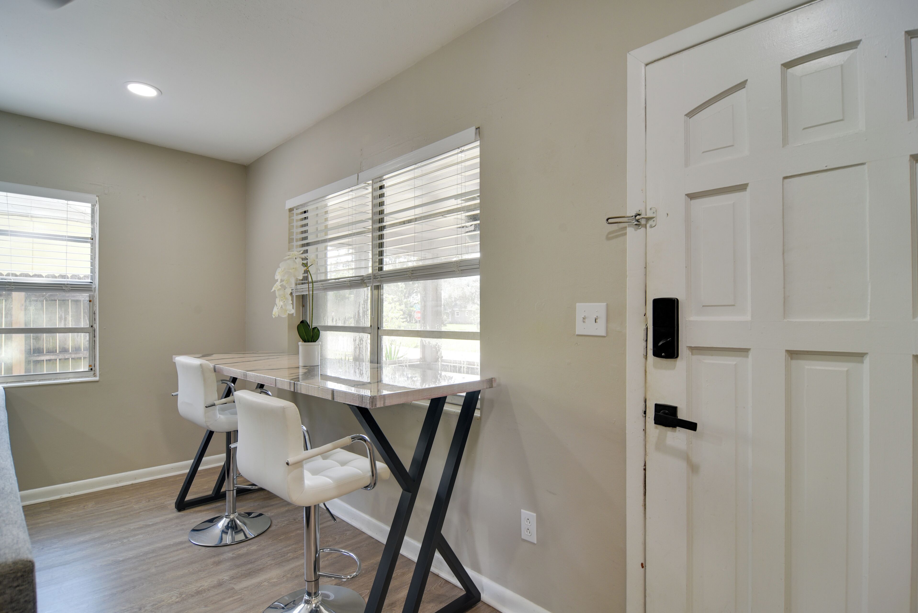 A modern kitchen with a white countertop, stainless steel appliances, and a black backsplash.