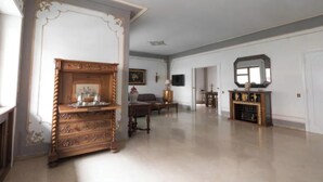 A spacious room with a large wooden dresser, a sofa, and a dining table.