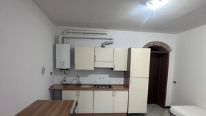A compact kitchen with a dining area, a built-in stove, and cabinets. - Dante4 Flat Cremona Old Town (Cremona)