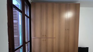 A room with a large wardrobe, a window, and a desk with a computer. - Dante4 Flat Cremona Old Town (Cremona)
