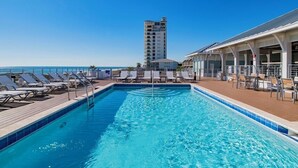 A swimming pool with lounge chairs and a building in the background.