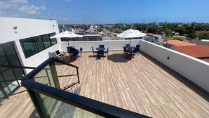 Eine Dachterrasse mit Sitzgelegenheiten und Blick auf die Stadt.