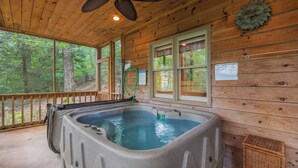 A wooden cabin with a hot tub, large windows, and a ceiling fan. - Azure Springs- Secluded Mountain Retreat in Dahlonega. Perfect for Families! (Dahlonega)