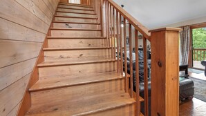 A wooden staircase with a railing leading to an upper floor. - Azure Springs- Secluded Mountain Retreat in Dahlonega. Perfect for Families! (Dahlonega)