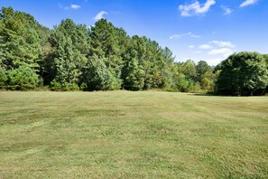 A grassy field with trees in the background. - Extended Stay 2BR • Relocation Friendly (Calhoun)