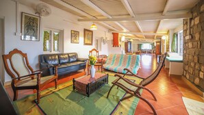 A spacious living room with a sofa, chairs, and a dining area. - Rico Retreat (Kotagiri)