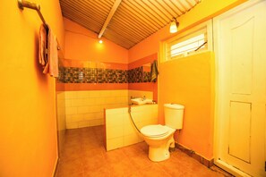 A bathroom with a toilet, sink, and tiled walls. - Rico Retreat (Kotagiri)