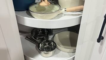 A kitchen cabinet with multiple shelves holding various kitchenware items.