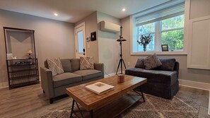 A living room with two sofas, a coffee table, a lamp, and a bookshelf.