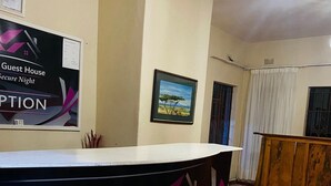 Een receptiebalie met een bord waarop staat: The Haven Guest House Peaceful Secure Night.
