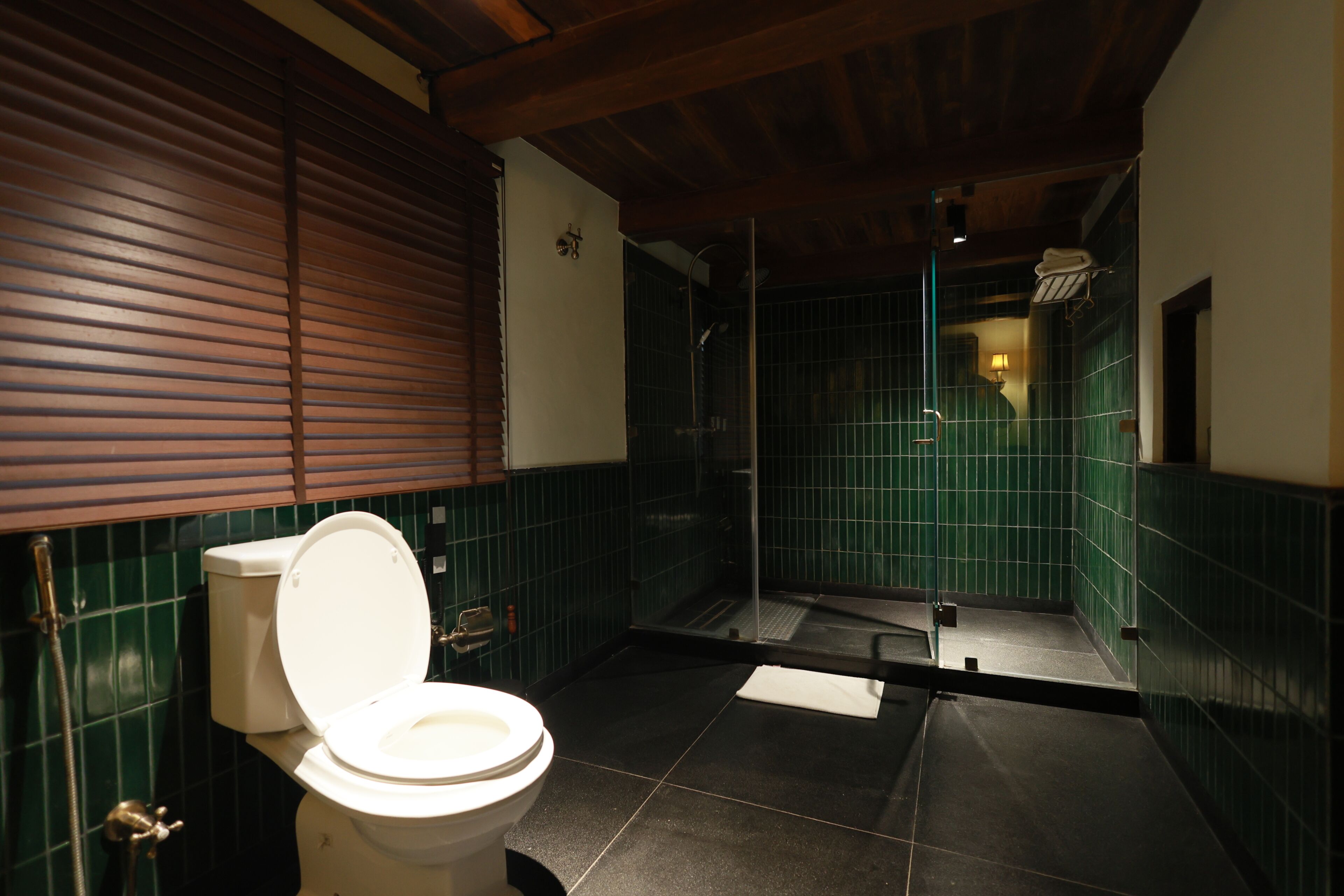 Een badkamer met toilet, douche en betegelde vloer.
