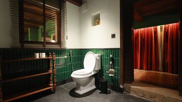 Une salle de bain comprenant des toilettes, un lavabo et un espace douche.