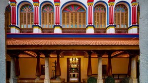 Un edificio tradizionale con un portico, colonne e un lampadario centrale.