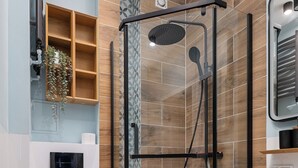 Een moderne badkamer met een douche met glazen wand, een toilet en een wastafelmeubel met een wastafel.