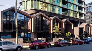Ein mehrstöckiges Hotel mit modernem Design, das eine geschwungene Fassade und große Fenster aufweist.