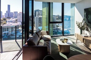 A modern living room with a city view, large windows, and a comfortable seating area.