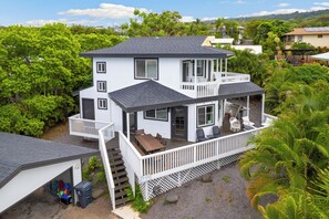 A two-story house with a balcony, a covered porch, and a garage.