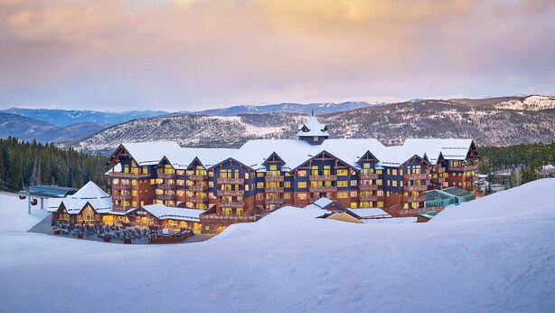 Een groot hotel met meerdere balkons en een skilift in de voorgrond.