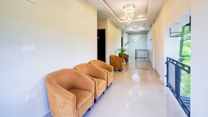 Una hall d'hotel moderna con un design pulito e minimalista, caratterizzata da una lunga reception e un'area lounge con poltrone confortevoli.