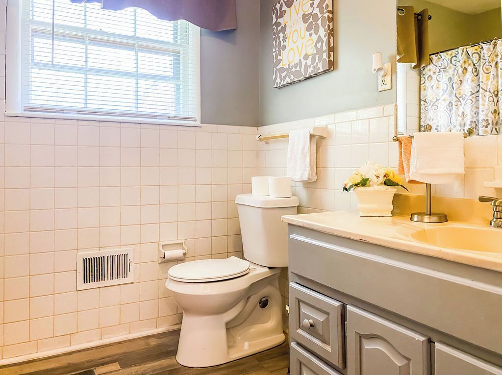 A bathroom with a toilet, sink, and vanity.