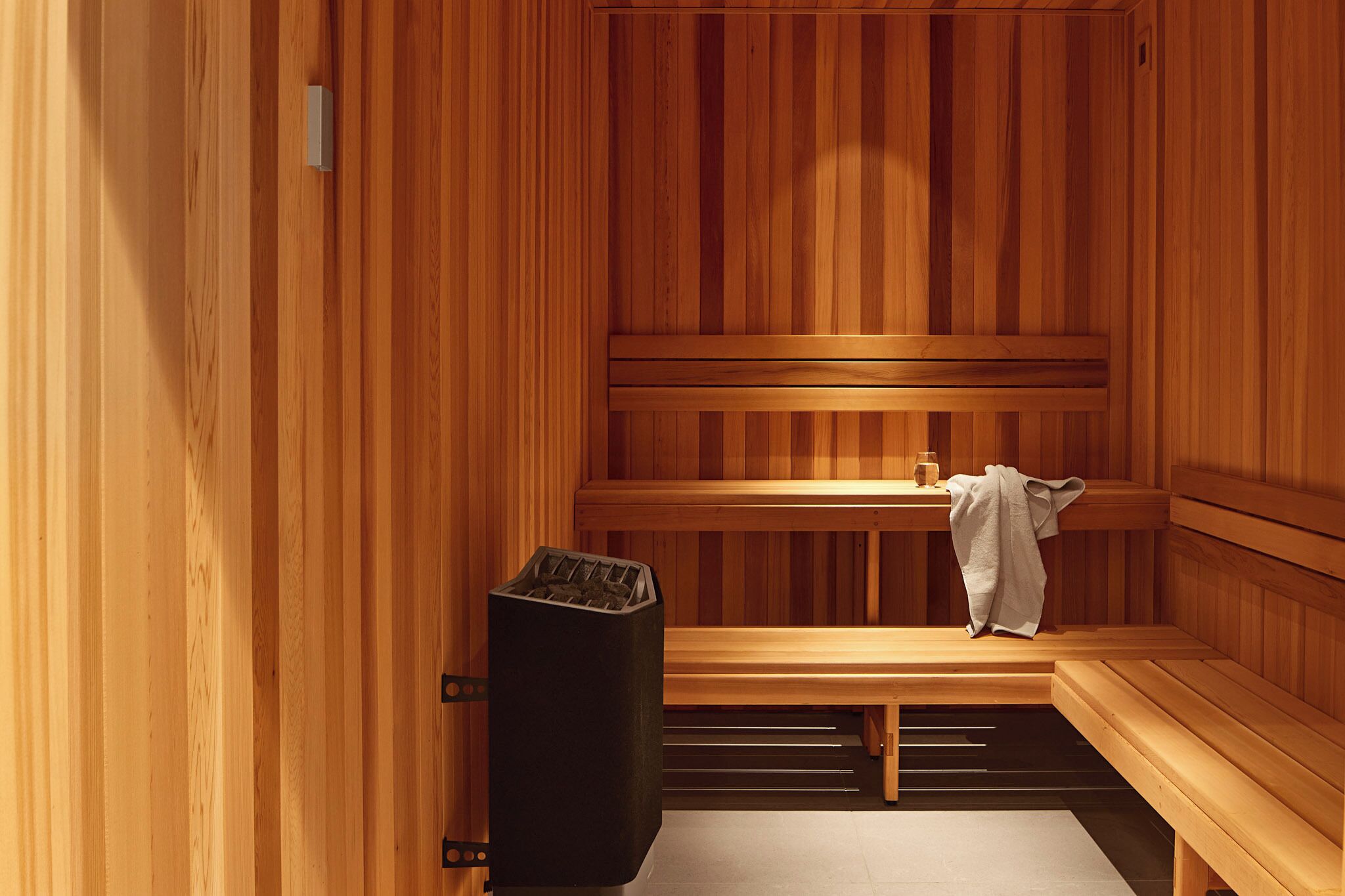 Een sauna met houten banken en een bankverwarming.