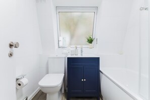 Un baño pequeño y moderno con inodoro, lavamanos y bañera.