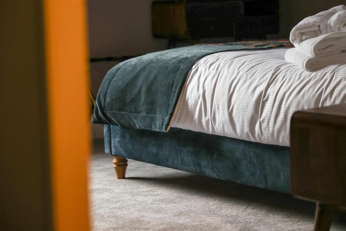 Une chambre à coucher avec un lit, une table de chevet et une lampe.