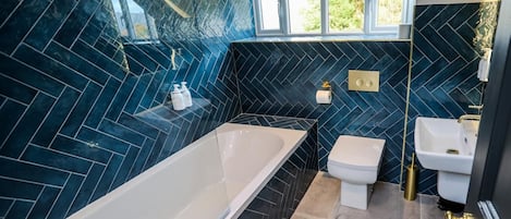 A modern bathroom with a freestanding bathtub, a toilet, and a sink.
