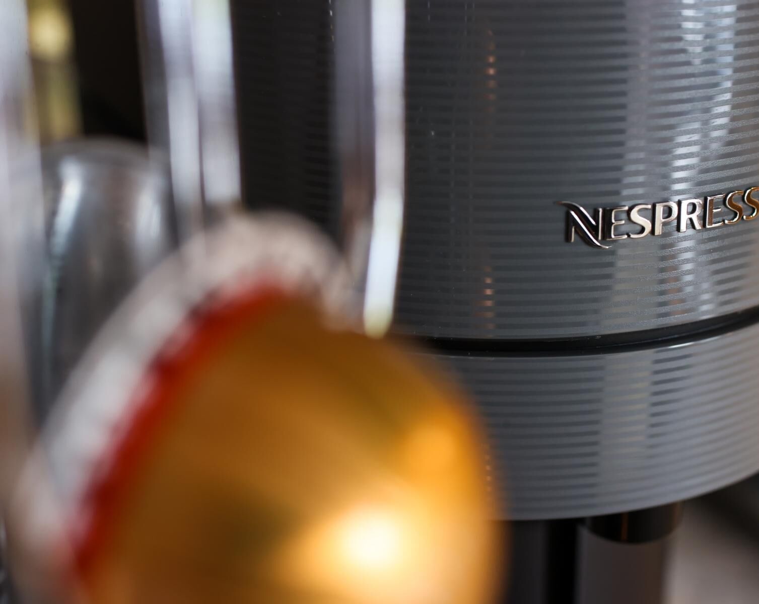 Un primo piano di una macchina Nespresso con finitura metallica e il marchio ben visibile.