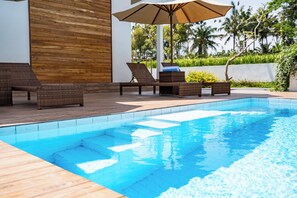 Piscine extérieure, parasols de plage, chaises longues