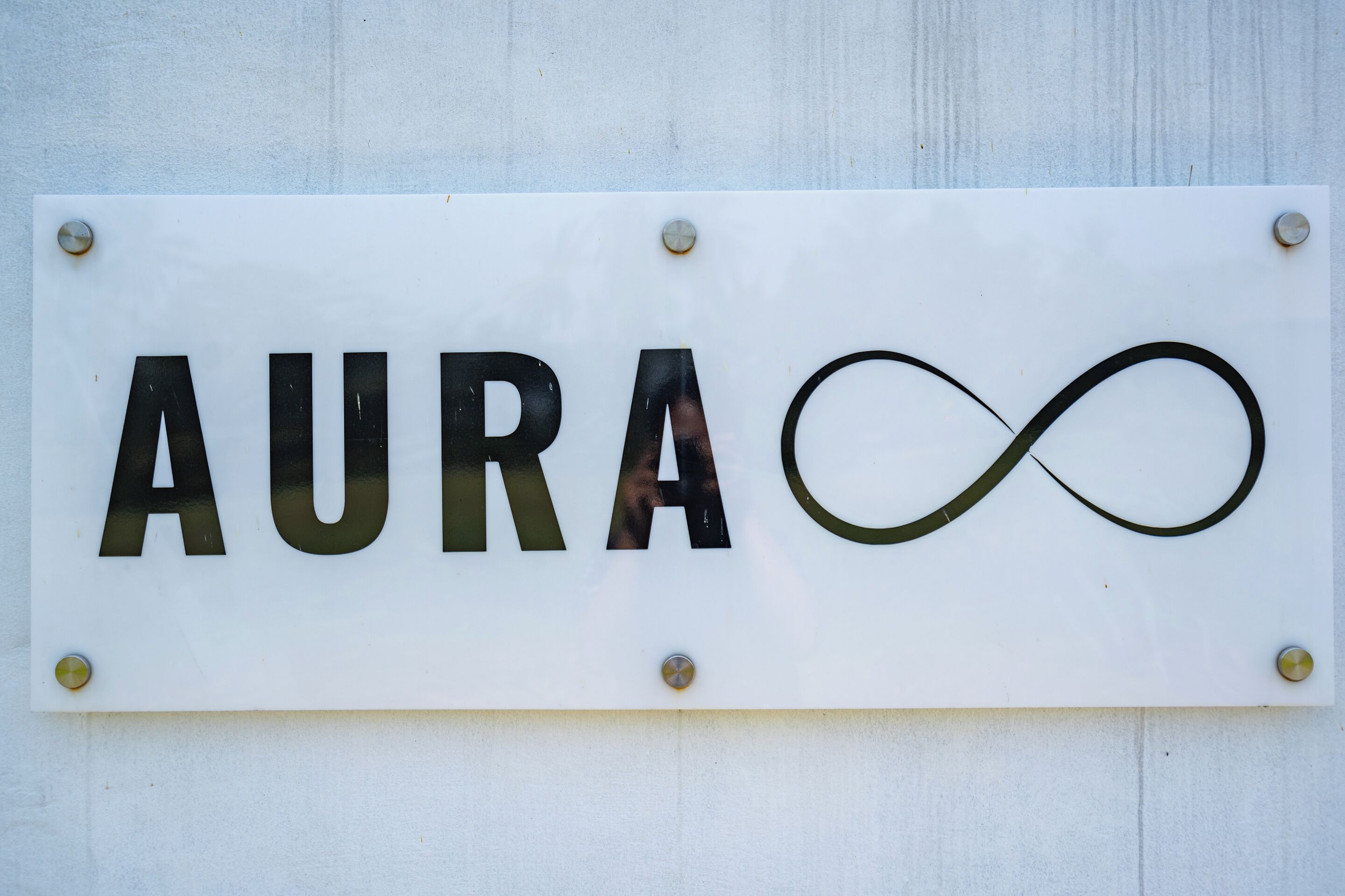 A sign with the word "AURA" and an infinity symbol.