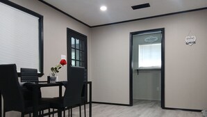 Een moderne kamer met een eethoek, een deur met de tekst 'Laundry' en een bordje met de tekst 'Welcome'.