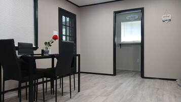 Une chambre moderne avec un coin repas, une porte portant l’inscription « Buanderie » et une pancarte « Bienvenue ».