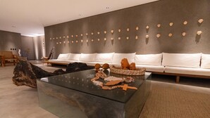A modern living room with a glass coffee table, white sofas, and a wall decorated with heart-shaped ornaments. - ORLA VILLAS - SÃO MIGUEL DOS MILAGRES (Passo de Camaragibe)