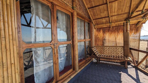 Una estructura de madera con ventanas grandes y techo de paja.