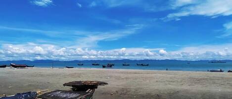 A beach with boats and a mountainous backdrop.