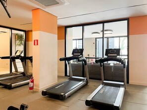 A gym with three treadmills, a fire extinguisher, and large windows. - Green Load Saúde (São Paulo)