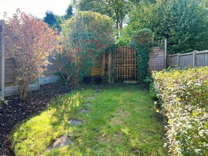 Stroll through a serene garden surrounded by lush plants and shrubs.